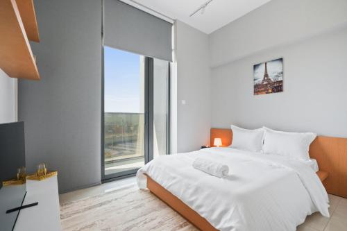 - une chambre avec un lit blanc et une grande fenêtre dans l'établissement Home Away From Home - New Studio, à Dubaï