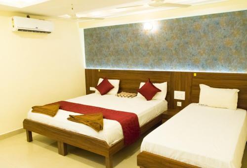 een hotelkamer met 2 bedden in een kamer bij KRR Grand inn in Coimbatore