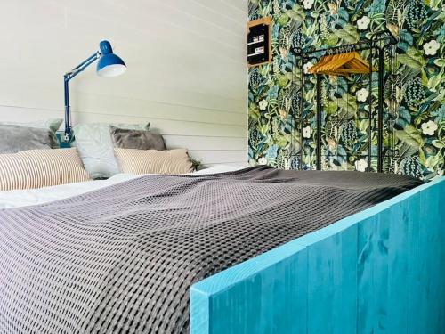 1 dormitorio con 1 cama con cabecero azul en Beautiful house on an island near Amsterdam 