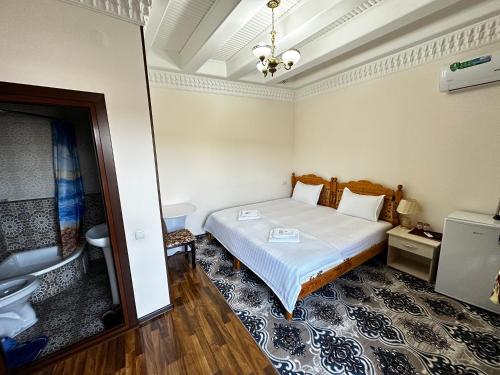 Habitación pequeña con cama y baño. en Hotel Mironshox en Bukhara