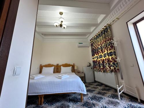 a bedroom with a bed and a mirror at Hotel Mironshox in Bukhara