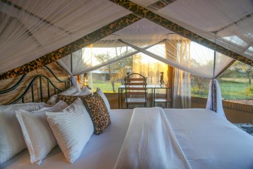 a bedroom with a bed in a tent at Ndoto Serengeti Camp in Serengeti