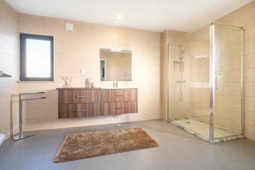 ein Bad mit einer Dusche und einem Waschbecken in der Unterkunft Villa Aboim - BY BEDZY in Guia