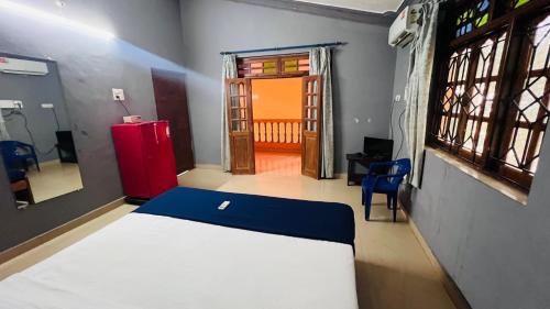 a room with a bed and a red refrigerator at Harsh angel holiday homes in Calangute