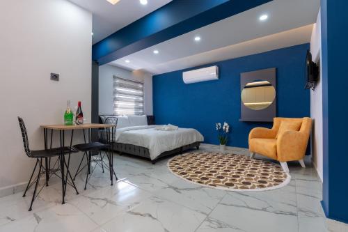 a blue bedroom with a bed and a table and chairs at ANTSUN in Antalya