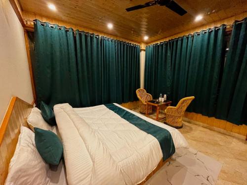 a bedroom with a large bed with a green curtain at Hotel Mid Orchard Kasol l River Side -Pure Veg Hotel in Kasol