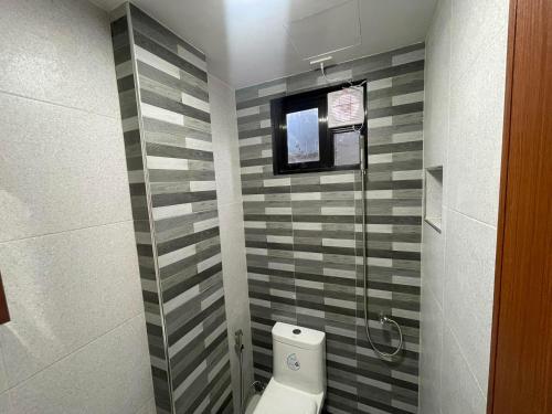 uma casa de banho com um WC e uma cabina de duche em vidro. em SHOWMECAS Alley Stay em Tagbilaran