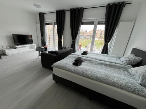 een slaapkamer met een groot bed en een bank bij Appartement Brussels Airport 2 in Machelen