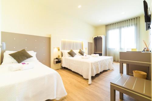 Un pat sau paturi într-o cameră la Hotel Calaluna