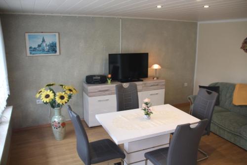 una pequeña sala de estar con mesa y TV. en Ferienhaus Mecklenburgische Seenplatte, 