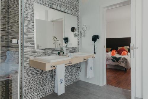 a bathroom with a sink and a mirror and a bed at Mare Hotel in Dos Hermanas