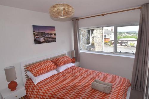 a bedroom with a bed and a large window at Family House - Breath Taking Views Over Mounts Bay in Newlyn