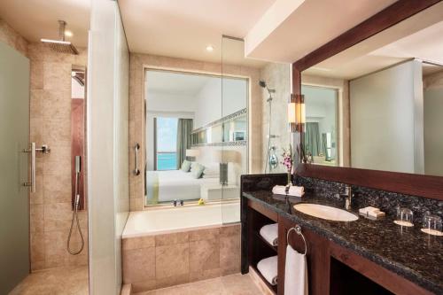 a bathroom with a sink and a tub and a shower at JA Ocean View Hotel in Dubai