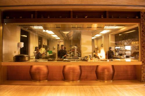 a bar with people standing behind a counter at JA Palm Tree Court, Dubai in Dubai