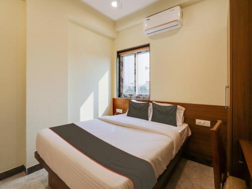 a bedroom with a large bed with a window at Super Collection O SRP LUXURY ROOMS in Hyderabad