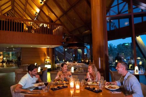 a group of people sitting at a table in a restaurant at JA Palm Tree Court, Dubai in Dubai