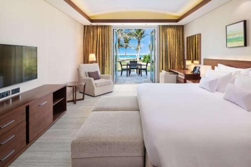 a hotel room with a large bed and a television at JA Palm Tree Court, Dubai in Dubai