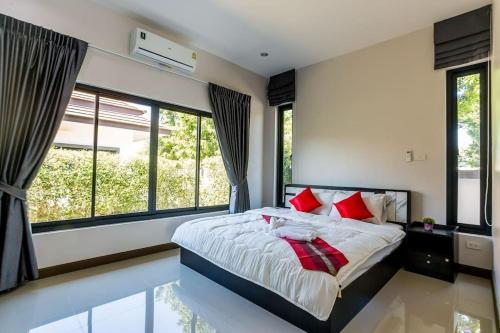 a bedroom with a large bed with red pillows at Villa ABBIE ! Amazing Pool Villa for family and Friends in Hua Hin