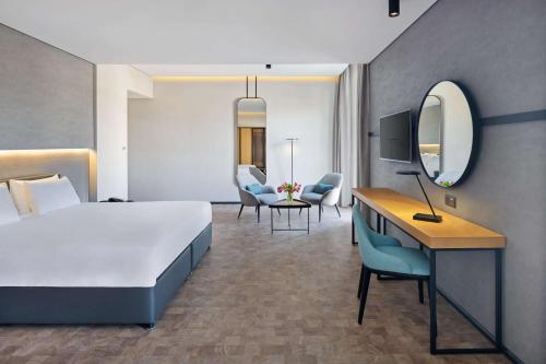 a hotel room with a bed and a desk and chairs at The Manor By JA in Dubai