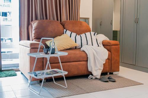 a living room with a couch and a side table at Cozy 1br walk to BTS and Airport Rail Link Close to Malls T in Bangkok