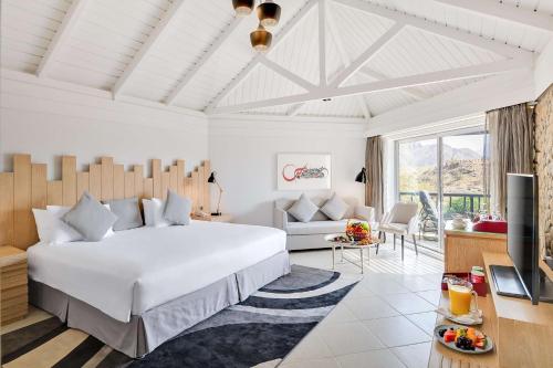 um quarto com uma cama grande e uma sala de estar em JA Hatta Fort Hotel em Hatta