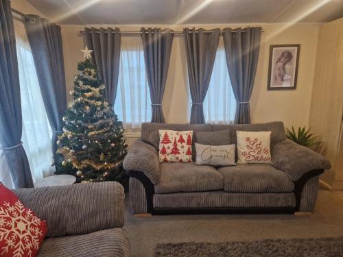 a living room with a christmas tree and a couch at Modern 6 Berth Static Caravan, Hunstanton in Hunstanton