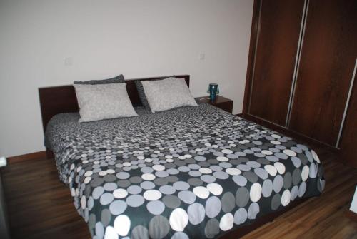 a bedroom with a bed with a black and white comforter at Pine Beach Spot in Ovar