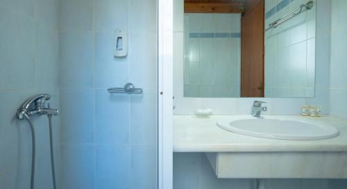 a bathroom with a sink and a shower with a mirror at Olive Τrees Garden in Lixouri