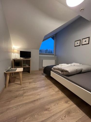 Schlafzimmer mit einem Bett, einem Schreibtisch und einem Fenster in der Unterkunft ,,Įlanka" in Rumšiškės