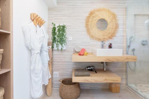 a bathroom with a sink and a wooden shelf at L'Aiglon By SCLS Locations in Vallauris