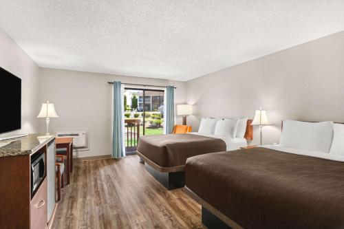 a hotel room with two beds and a flat screen tv at Columbia River Hotel, Ascend Hotel Collection in The Dalles in The Dalles