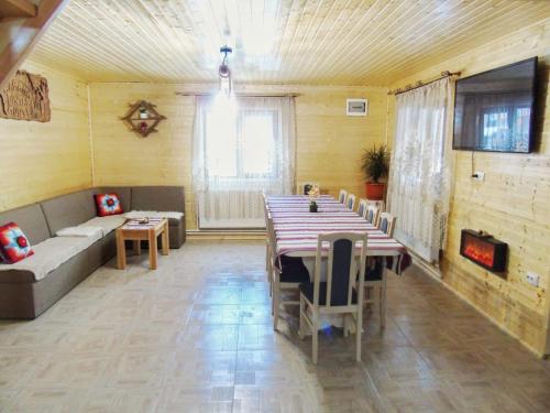 a living room with a long table and a couch at Cabana Dintre Munti in Vidra