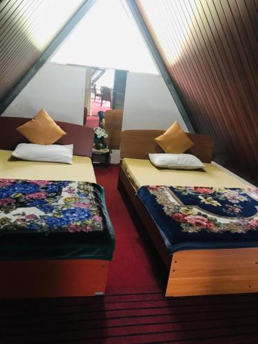 two beds in a attic room with sidx sidx sidx sidx at White house in Nuwara Eliya