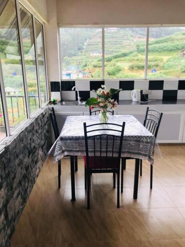 a dining room table with chairs and a vase of flowers on it at White house in Nuwara Eliya
