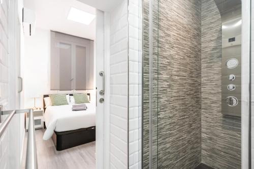 a bedroom with a bed and a shower at Chueca San Antón Apartment in Madrid
