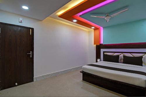 a bedroom with a bed with a colorful ceiling at Super OYO AIRPORT PALACE in kolkata