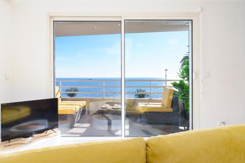 a living room with a yellow couch and a view of the ocean at L'Aiglon By SCLS Locations in Vallauris