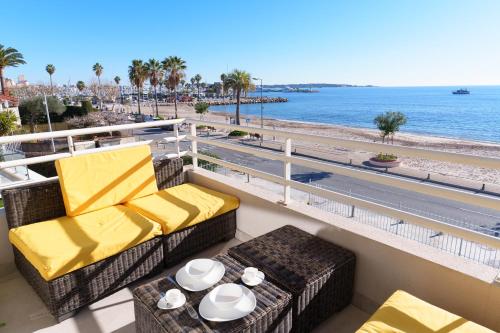 a balcony with chairs and a table and the beach at L'Aiglon By SCLS Locations in Vallauris