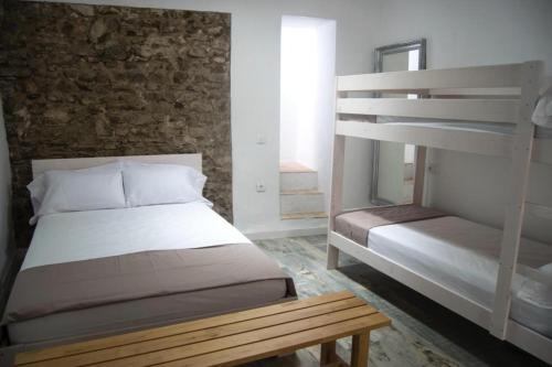 a bedroom with two bunk beds and a bench at Casaimpecablecentro in Tarifa