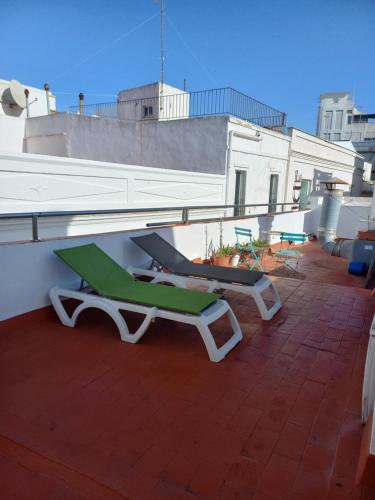 a green and white lounge chair on a roof at Casaimpecablecentro in Tarifa