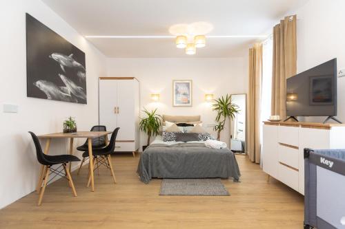 1 dormitorio con 1 cama y 1 mesa con sillas en C85Apartament KILO, en Lublin