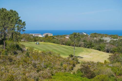 an aerial view of a golf course with the ocean in the background at Pezula 's Paradise in the Sun - No Loadshedding in Knysna
