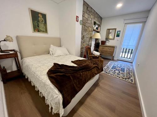 Un dormitorio con una cama con una manta encima. en Ninho do Melro II - Turismo Rural Bragança, en Bragança