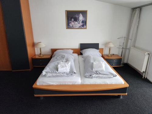 a bedroom with two beds and two night stands at Hotel & Restaurant Heidekrug in Pinneberg in Appen