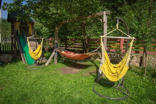 two hammocks on a swing set in a yard at Natural e Simplu in Petroşani