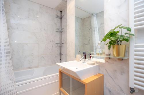 a bathroom with a sink and a tub and a toilet at Buarcos Ocean Village in Buarcos