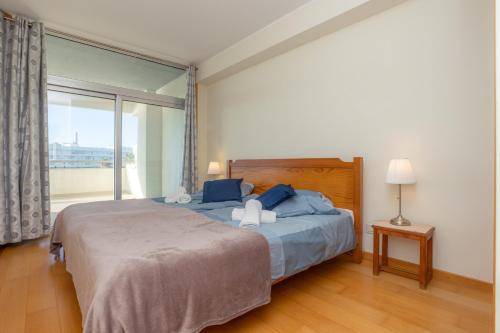 a bedroom with a large bed and a large window at Buarcos Ocean Village in Buarcos