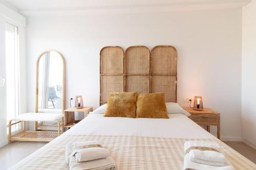 um quarto com uma cama grande e almofadas douradas em Global Properties, Apartamento con terraza y vistas al mar y a la montaña em Canet d'En Berenguer