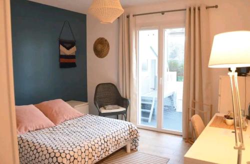 a bedroom with a bed and a sliding glass door at Chambre indépendante - WC et SDB privatifs in Le Pellerin