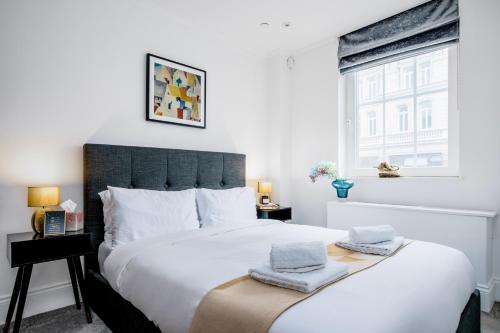 ein Schlafzimmer mit einem großen Bett mit zwei Handtüchern darauf in der Unterkunft Elegant central London flat - ideal for weekend city break in London